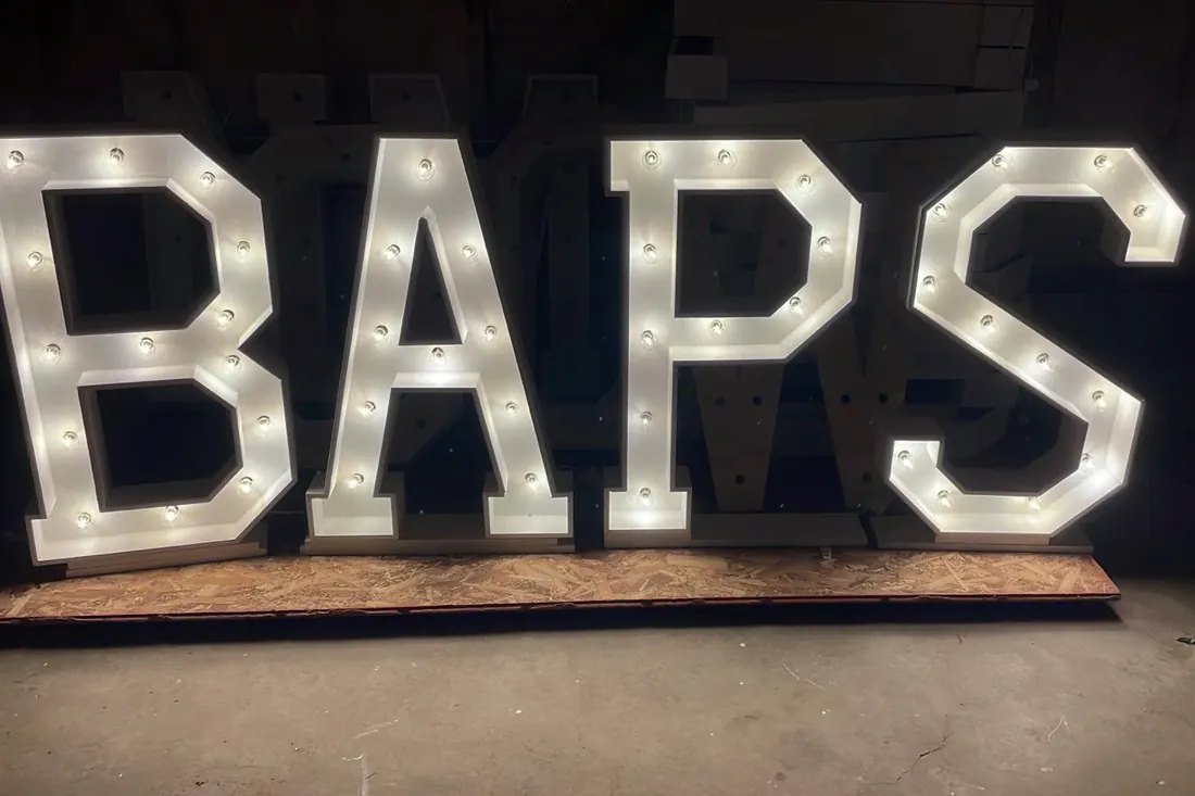 BAPS spelled in brightly lit marquee letters