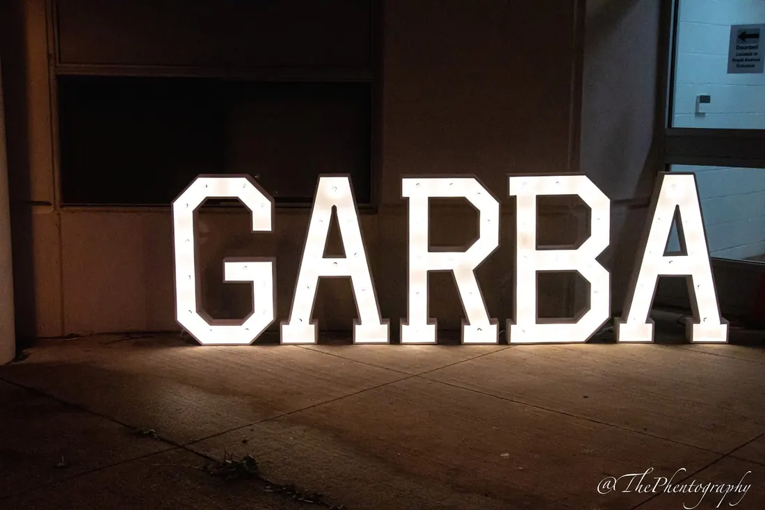 GARBA spelled in glowing marquee letters in a dark hall